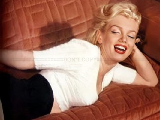 Photo Marilyn Monroe détendue sur un canapé en velours texturé en 1953 - 15x20