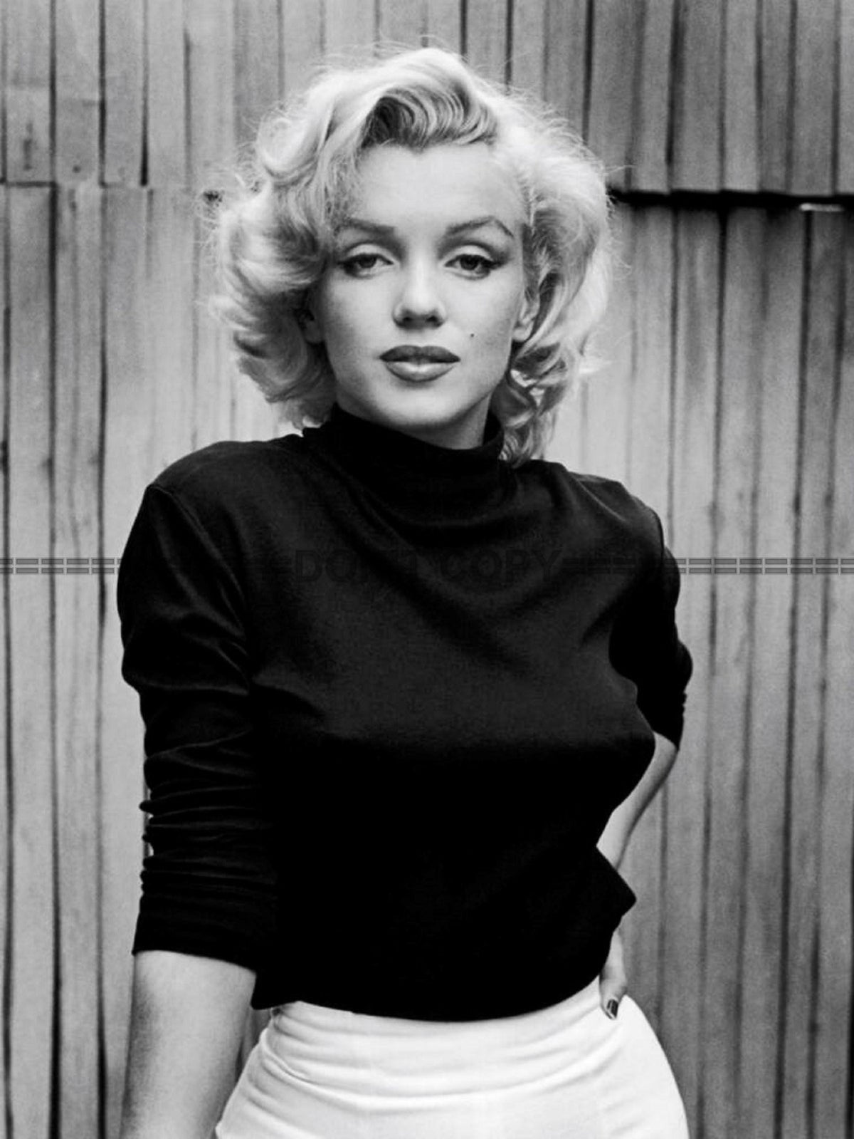 Photo Marilyn Monroe vêtue d'un pull noir et d'une jupe claire en 1953 - 15x20