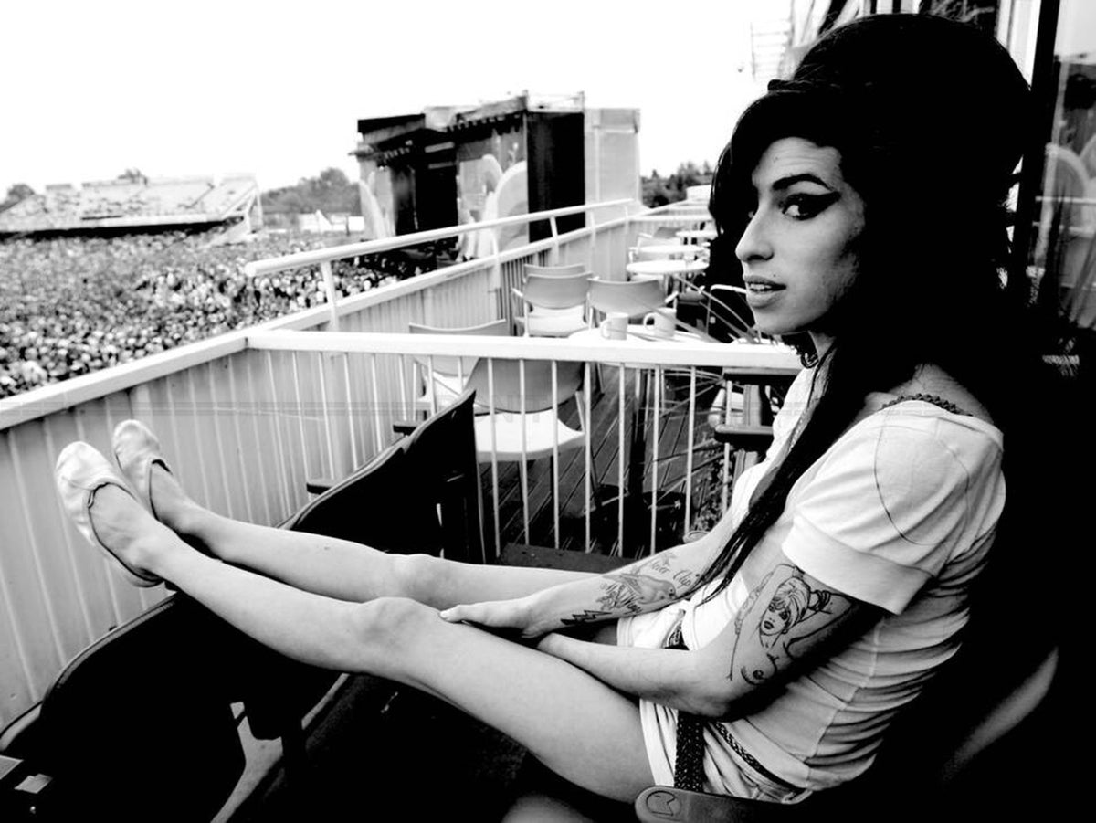 Photo Amy Winehouse assise de profil sur un balcon en hauteur en 2007 - 15 x 20