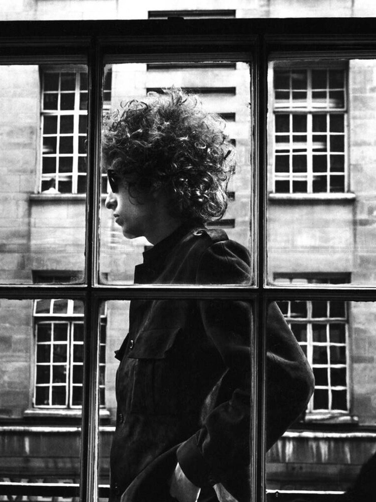 Photo Bob Dylan passant devant une vitre dans la rue, à Londres (1966) - 15 x 20