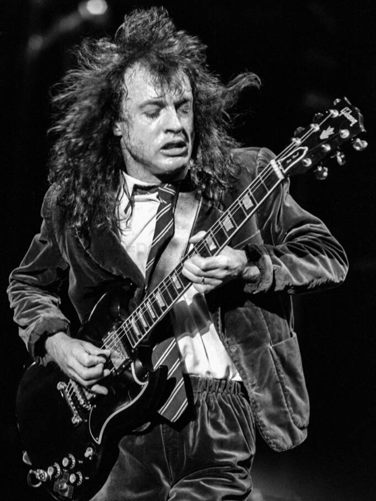 Photo Angus Young en uniforme d'écolier avec guitare en concert, 1991 - 15 x 20