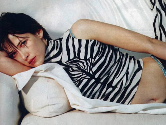 Photo Sophie Marceau allongée sur un canapé vêtue d'un top à motif zébré - 15×20