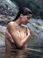 Photo Laetitia Casta dans l'eau entourée de rochers les cheveux mouillés - 15x20