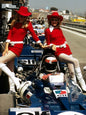 Photo Jackie Stewart avec 2 Grid Girls - paddock F1 années 70 - Couleur - 15x20