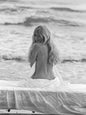 Photo Brigitte Bardot de dos, assise sur un lit face à la mer en 1965 - 15x20