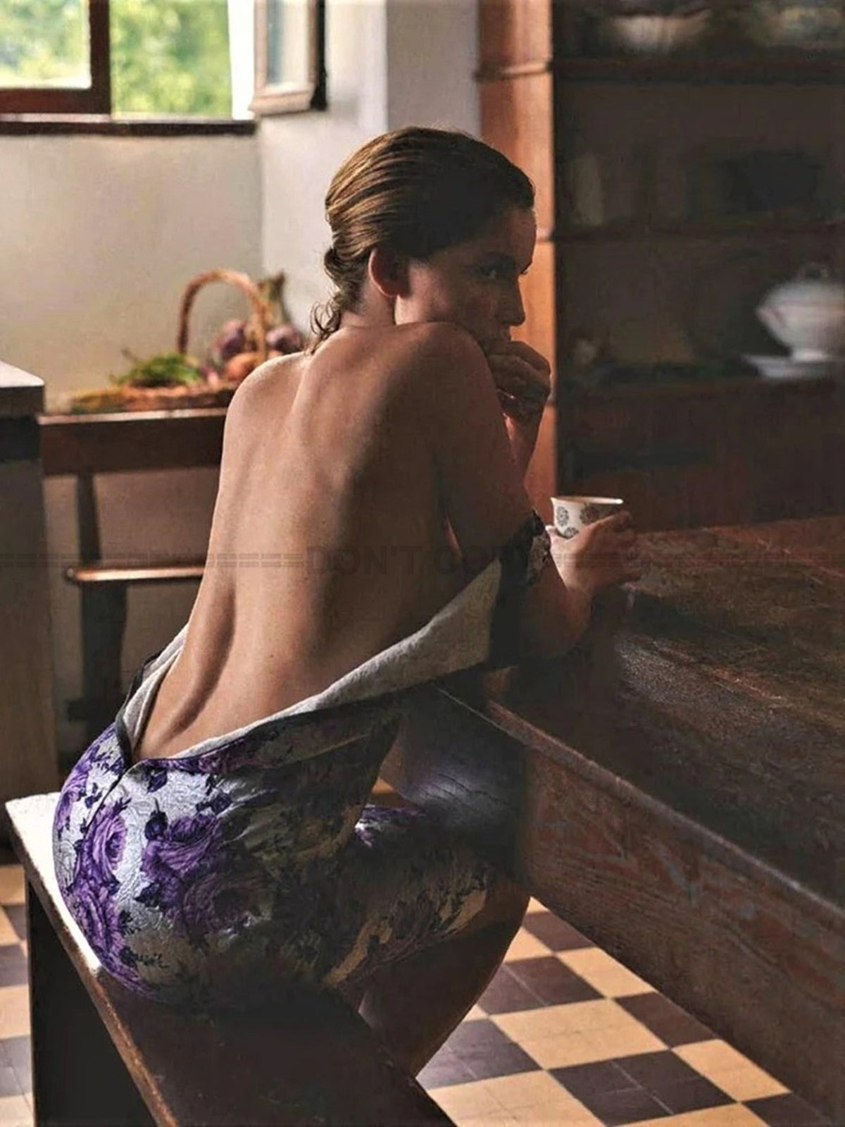 Photo Laetitia Casta assise sur un banc à une table en tenant une tasse - 15x20
