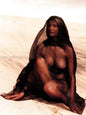 Photo Laetitia Casta assise sur le sable drapée d'un voile sombre - 15x20