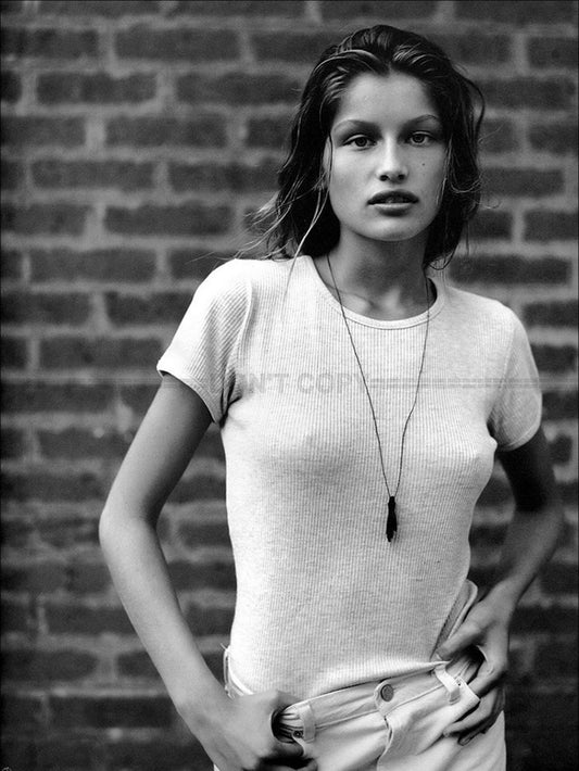 Photo Laetitia Casta en t-shirt et pantalon devant un mur en briques - 15x20