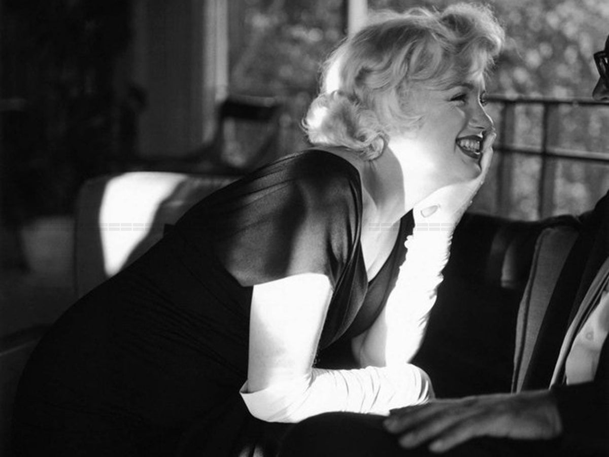 Photo Marilyn Monroe en robe noire et gants blancs lors d'une fête, 1958 - 15x20